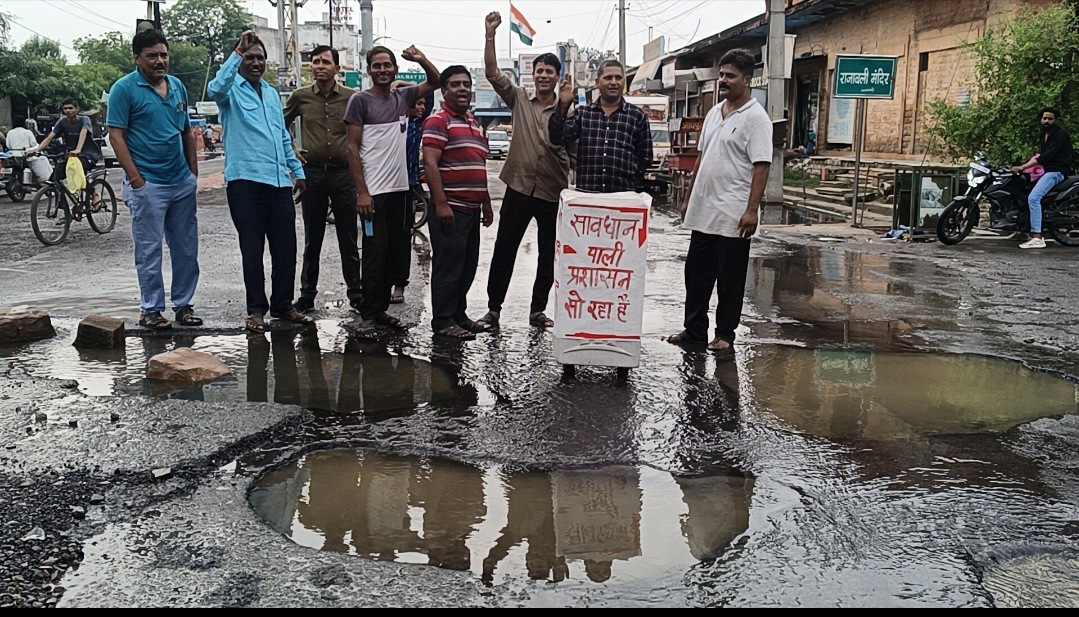 राजा बली सर्कल पर गहरे गड्ढों से लोग परेशान, बीच सड़क पर लगाया “प्रशासन सो रहा है” का बोर्ड
